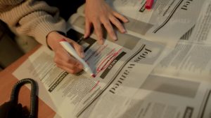Donna che evidenzia giornale